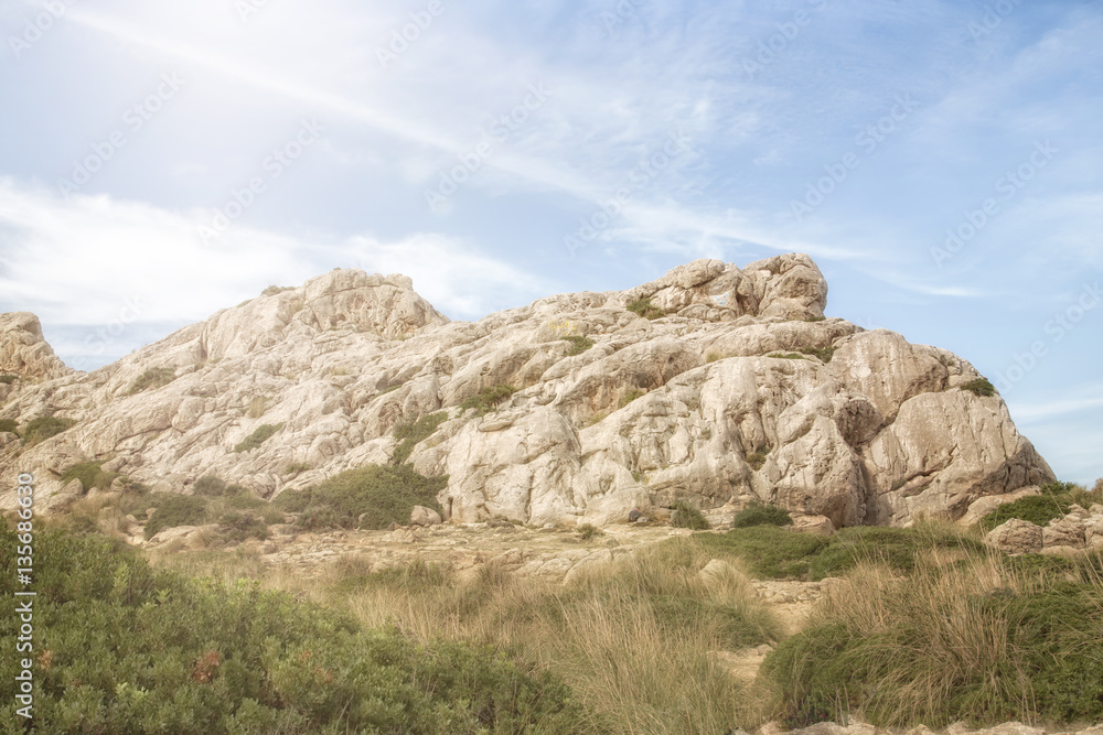 Steinhügel am Meer auf Mallorca mit blauem Himmel und Gegenlicht