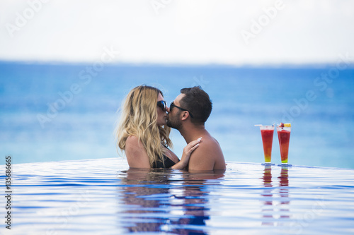 Honeymoon romantic lovers vacation on a tropical beach. Young happy lovers on romantic travel honeymoon having fun on vacation summer holidays romance. photo