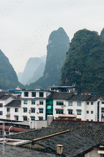 The foggy view of the cityscape and karst rock mountains in Yangshuo, Guilin region, Guangxi Province, China. © Iryna