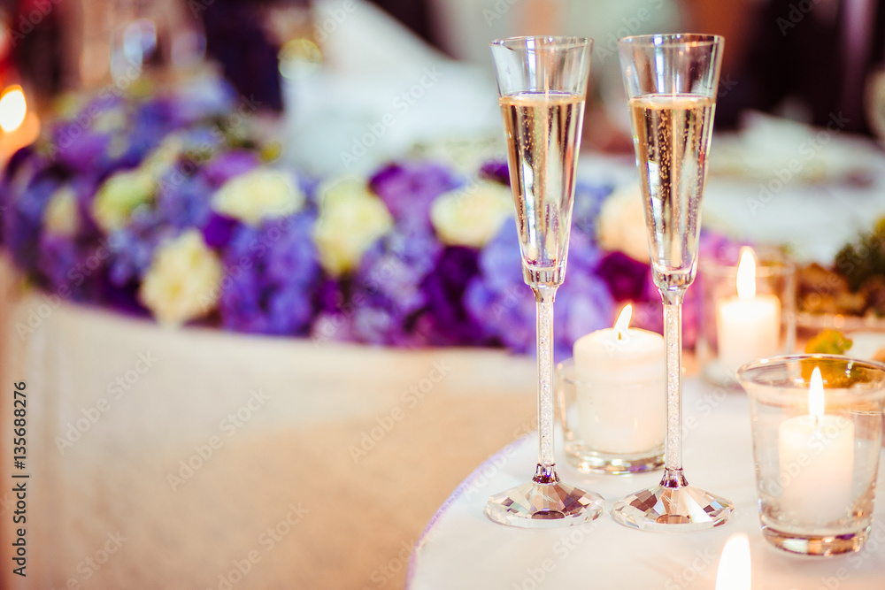 The glass of champagne stands near candles The glass of champagne stands near candles