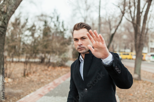 Slika na platnu the man in a strict suit and a coat walks