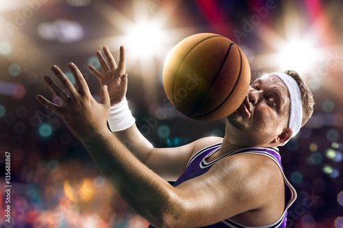 Fat Basketball non professional player catch the ball. Bokeh background © Anna Stakhiv