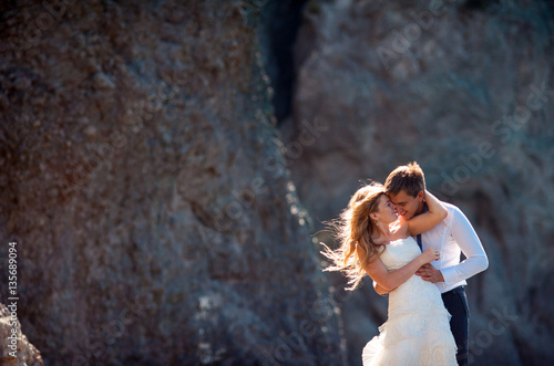 Lovely wedding couple softly hugging. Beautiful mountain landscape on background