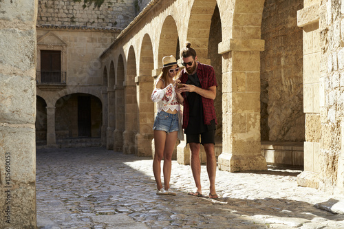 A couple sightseeing in Ibiza using a phone for guidance