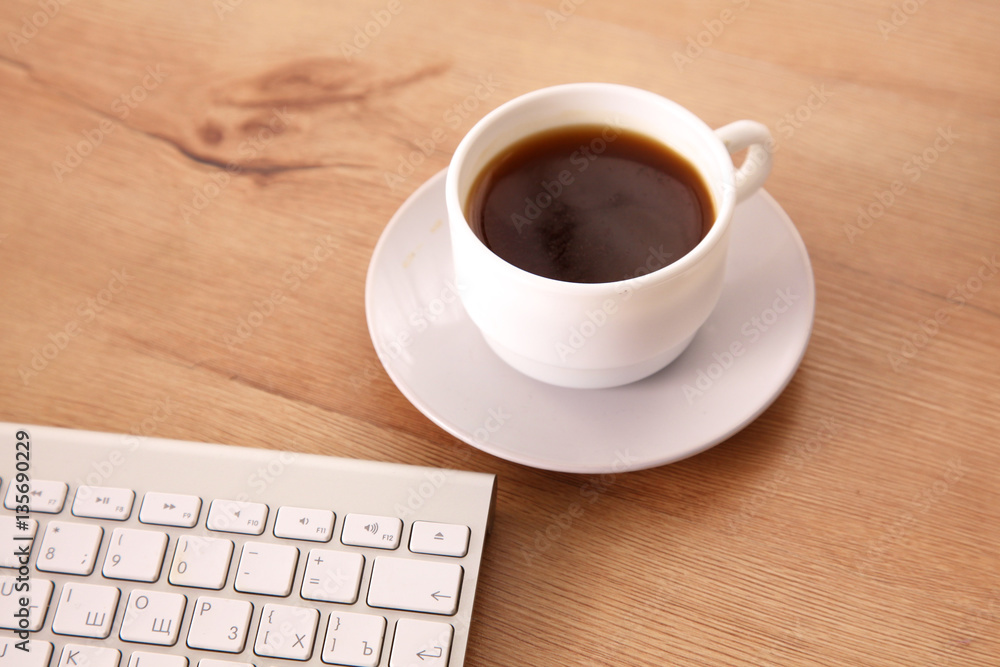 on the desktop computer and a cup of coffee on the desktop computer and a cup of coffee