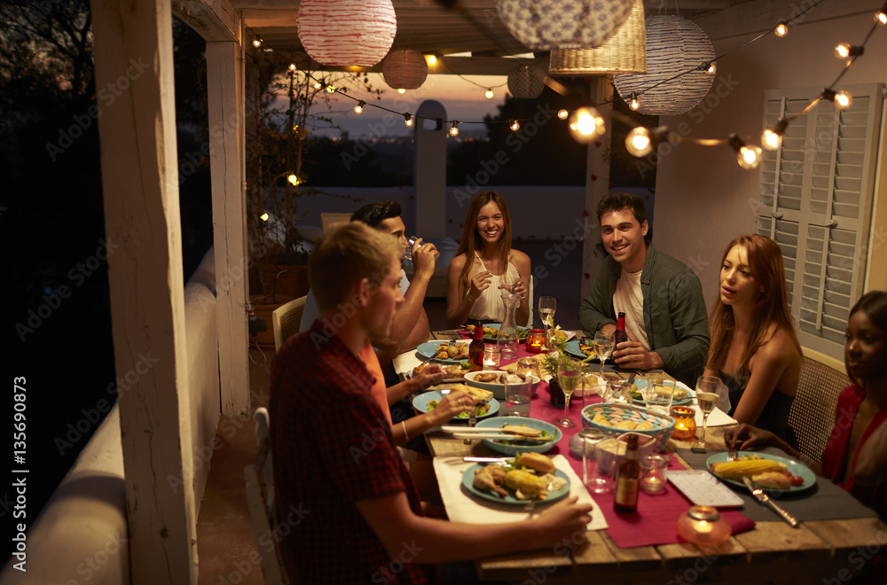 Friends talking at a dinner party on a patio, Ibiza, Spain - obrazy, fototapety, plakaty 