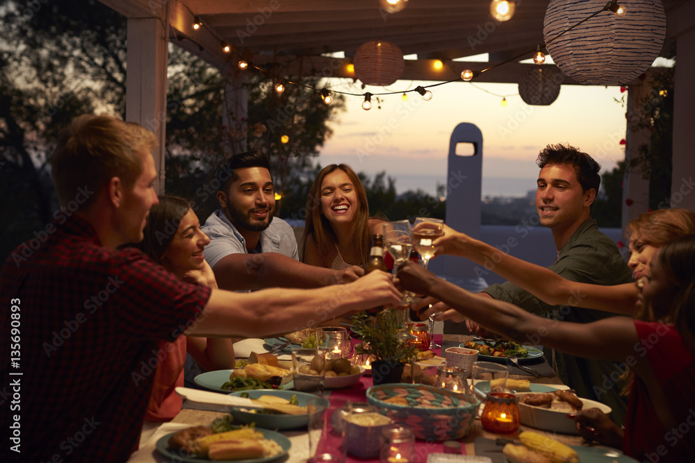 Friends make a toast at a dinner party on a patio, close up - obrazy, fototapety, plakaty 