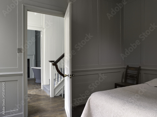 View across bedroom to bathroom in a renovated georgian townhouse. photo