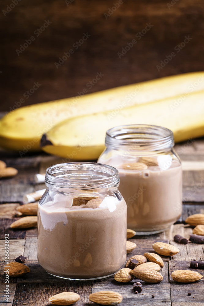 Chocolate almond smoothie in glass jars, old wooden background, Chocolate almond smoothie in glass jars, old wooden background,