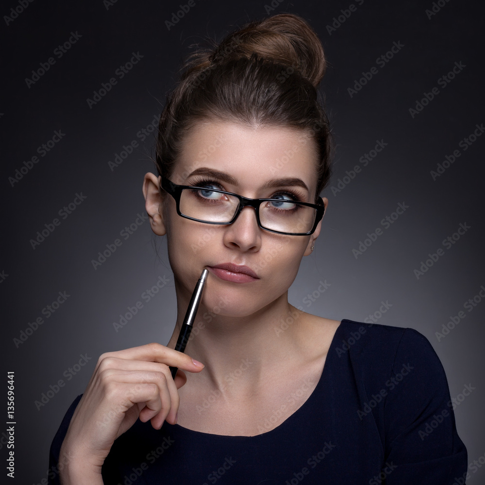 Portrait of a beautiful woman in a business style. On a gray bac Portrait of a beautiful woman in a business style. On a gray bac