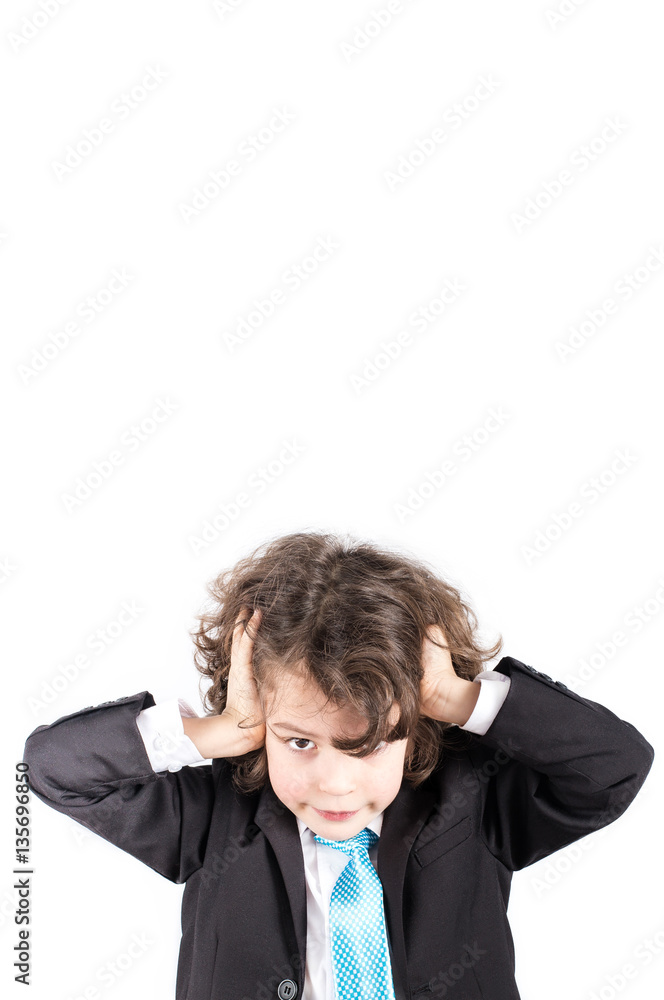 Little curly boy in a business suit sitting at his desk, his hands clasped his head with interest looking at the camera. White background. Little curly boy in a business suit sitting at his desk, his hands clasped his head with interest looking at the camera. White background.