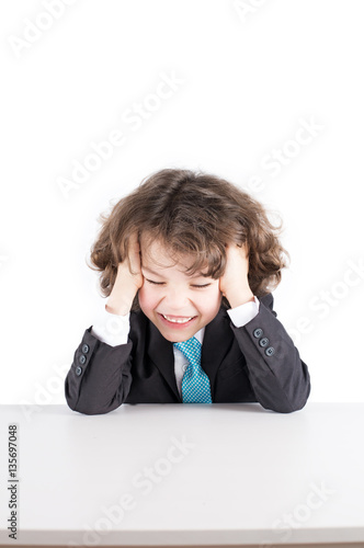 Little curly manager in a business suit sitting at his desk, his head in his hands, laughing with his eyes closed. White background.