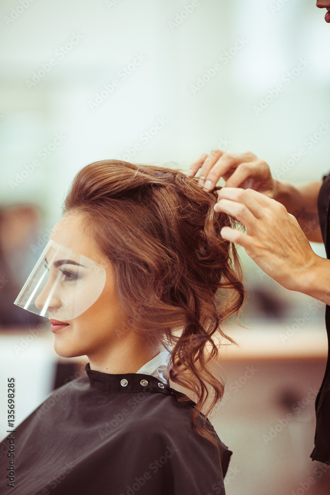 The haidresser doing a hairdo for bride