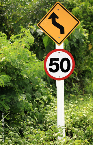 Country road with speed limit signs of 50 km / hour,color toned.