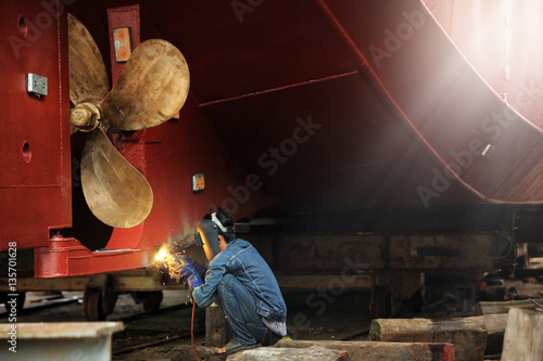 Welder man working in ship yard,color toned.