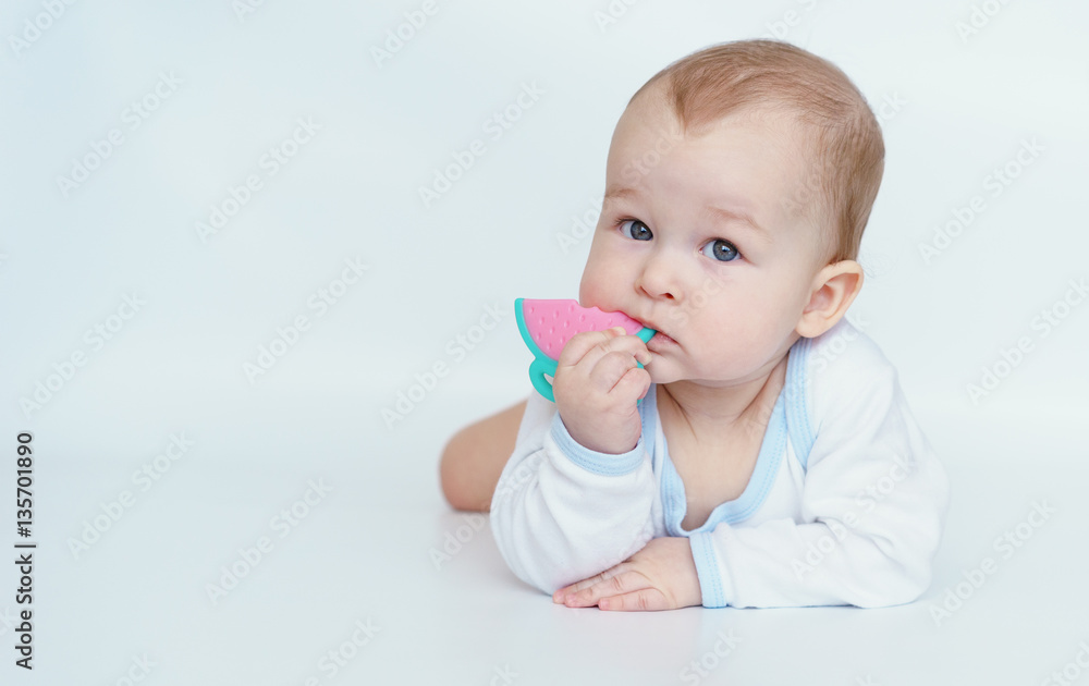 The baby lying on his stomach and gnaws teethers The baby lying on his stomach and gnaws teethers