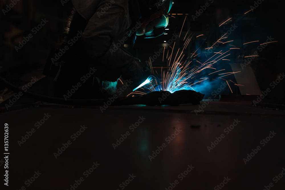 Welder of Metal Welding with sparks and smoke in manufacturing Welder of Metal Welding with sparks and smoke in manufacturing