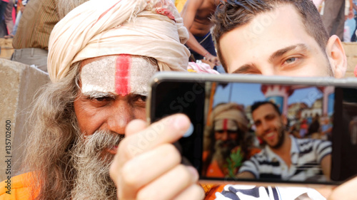 Canvas Print Tourist taking a selfie with Sadhu Holy Man in India