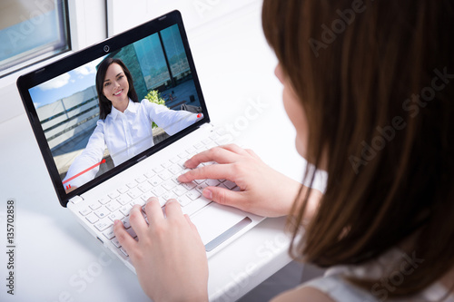 young woman watching video blog on laptop