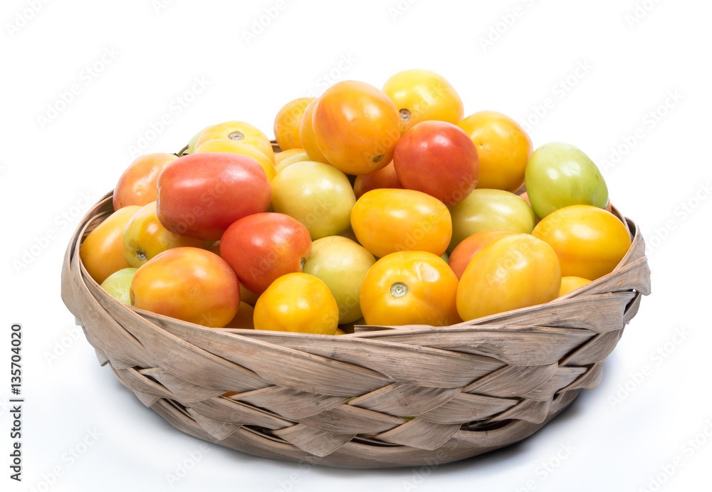 Mixed coloured tomatoes in a natural palm tree basket Mixed coloured tomatoes in a natural palm tree basket