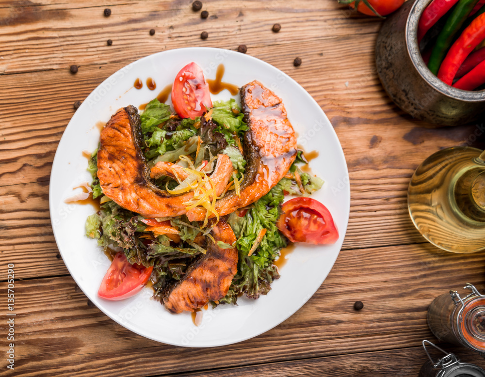 Salmon steak in white dish with vegetables Salmon steak in white dish with vegetables