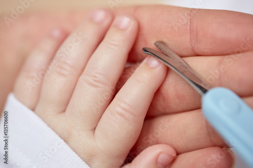 close up of hand with scissors trimming baby nails