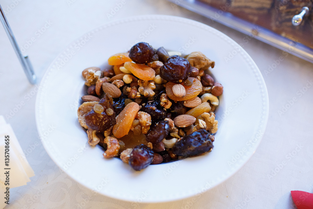 Mix nuts, dry fruits and grapes in white plate