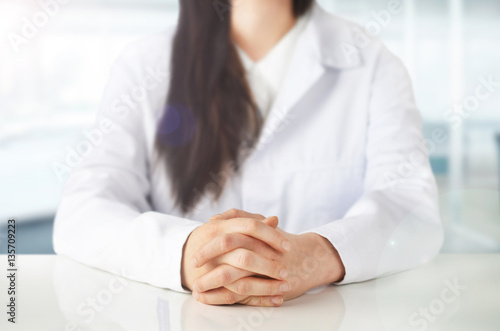 Young female doctor sitting at office desk