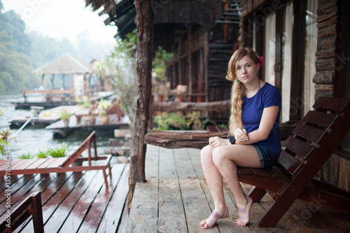 image of happy young woman at beach house on the River Kwai in Thailand
