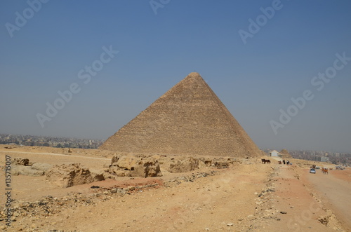 Pyramid in sand dust under gray clouds