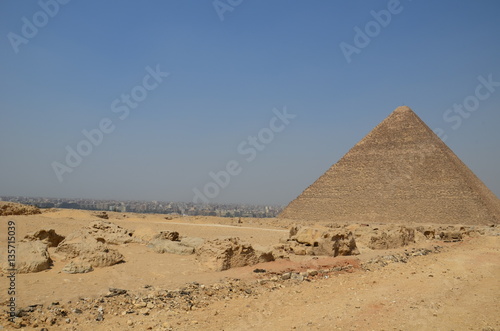 Pyramid in sand dust under gray clouds