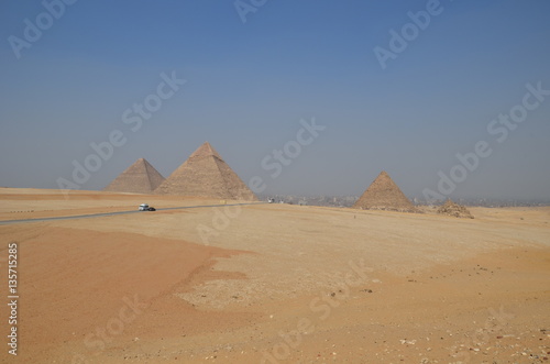 Pyramid in sand dust under gray clouds