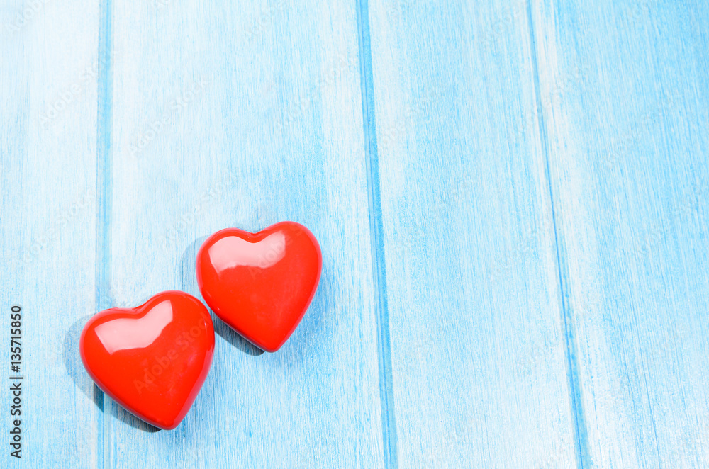 Couple of glossy red hearts for Valentine's day on blue wooden table Couple of glossy red hearts for Valentine's day on blue wooden table