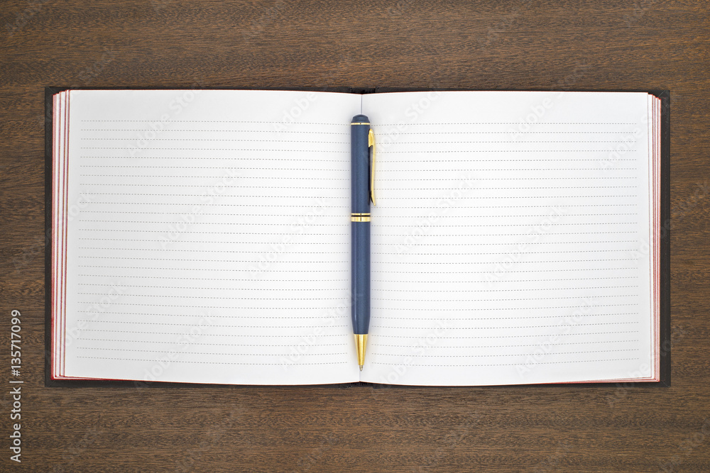 new notebook with pen on the brown wooden table new notebook with pen on the brown wooden table