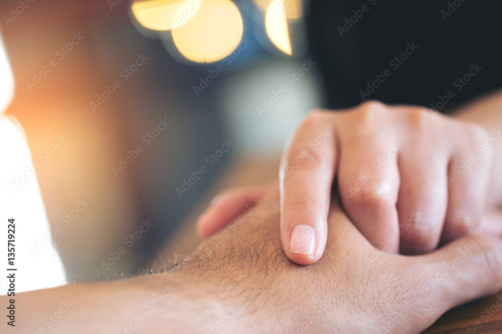 A man and a woman holding each other hands with feeling love and blue bokeh background