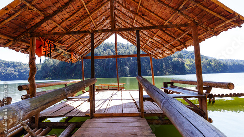 Fototapeta Naklejka Na Ścianę i Meble -  Small hut on bamboo raft in lake and camping site with pine tree