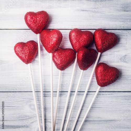 Valentine’s day backgroundt with red hearts over light wooden photo