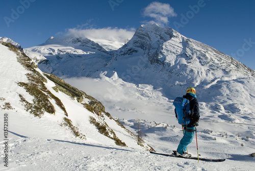 landscape of the Swiss Alps covered by snow and skier who practice ski mountaineering looking mountains and the horizon, on a sunny day, Switzerland, Simplon Pass, Mount Breithorn
