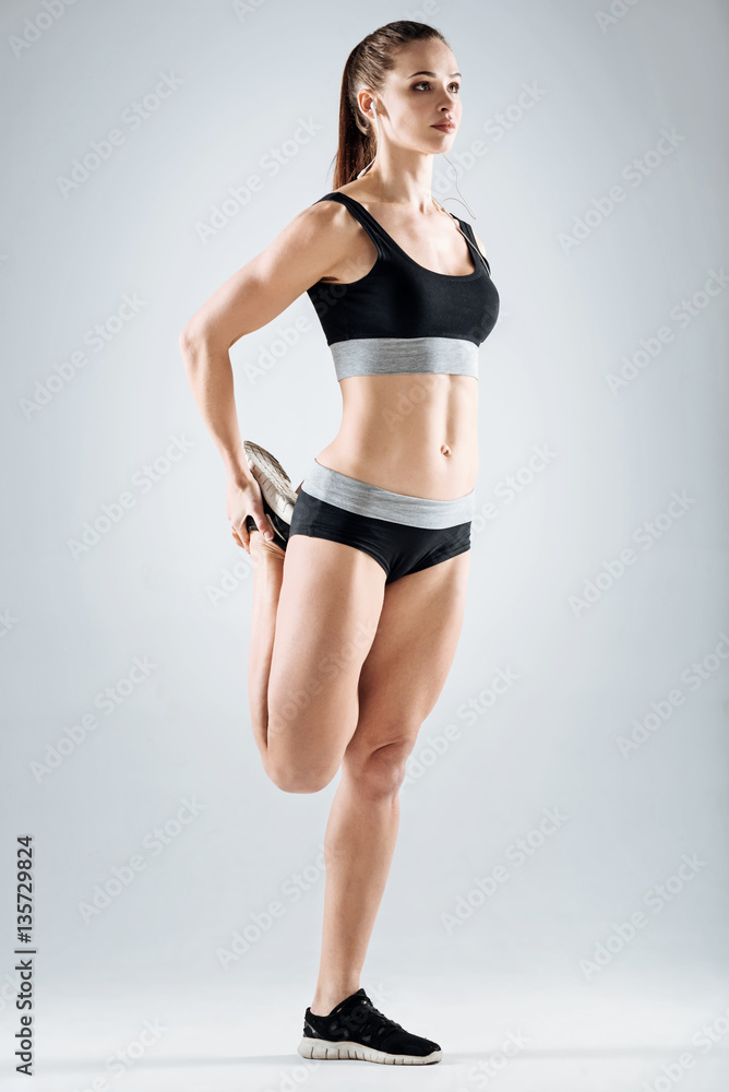 Satisfied girl doing exercises on a grey background Satisfied girl doing exercises on a grey background