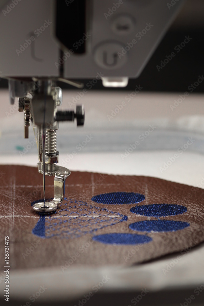 Embroidery with embroidery machine - dog paw on brown leather - fill -  motion blur at working needle bar, background blanked out blurry Stock  Photo | Adobe Stock