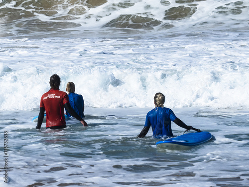 A couple of two surfers with their boards trying to get out trou