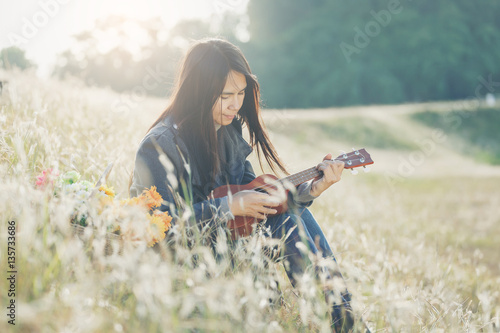 Beautiful girl relax by playing acoustic guitalele photo