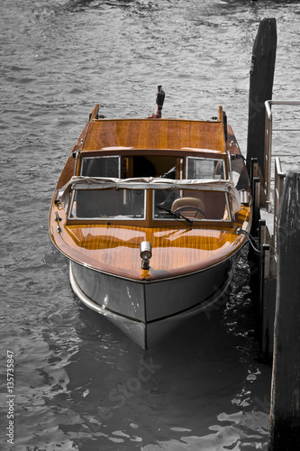 Luxury wooden speedboat with teak deck, moored in a canal of Venice - Italy