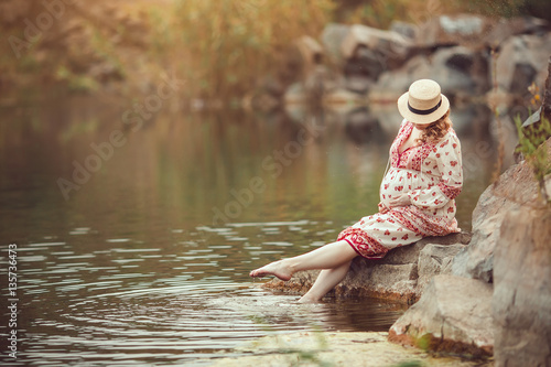 Fototapeta Naklejka Na Ścianę i Meble -  Pregnant woman resting on the river