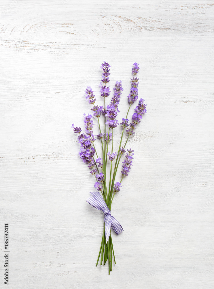 Fototapeta premium Bundle of lavender on old wooden board painted white.