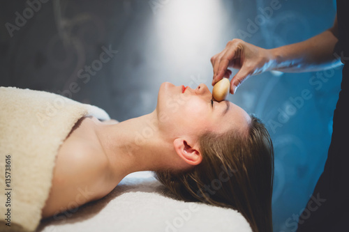 Masseur massaging face with heated objects © NDABCREATIVITY