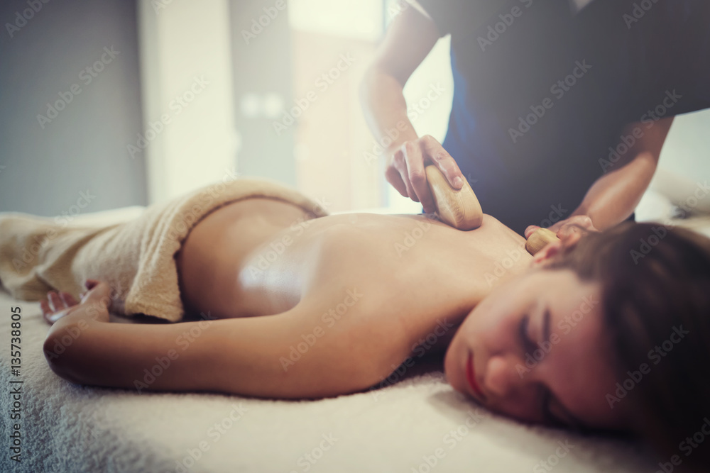 Fototapeta premium Masseur massaging female on bed