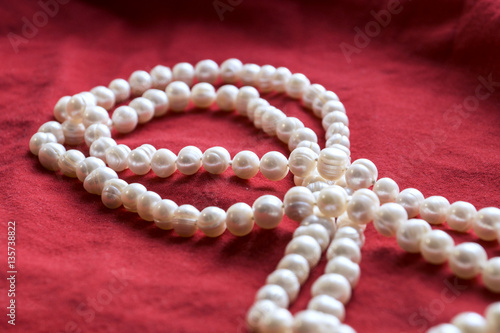 pearls and a pearl necklace on a red background for valentine day