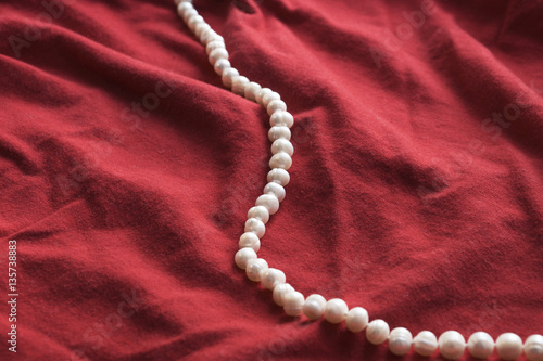 pearls and a pearl necklace on a red background for valentine day