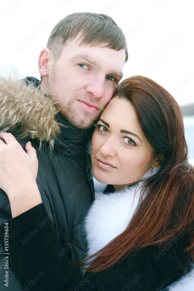 Winter love story. Young couple engagement outdoors near the riv Winter love story. Young couple engagement outdoors near the riv